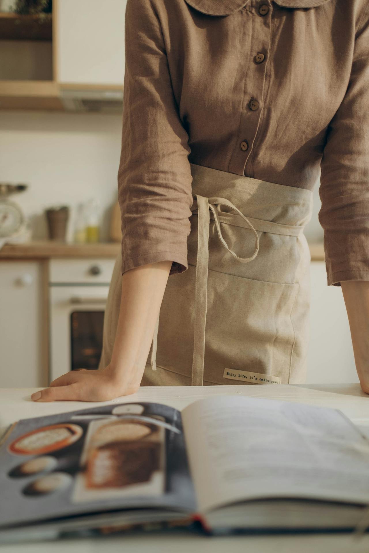 femme avec un tablier et un livre de recettes